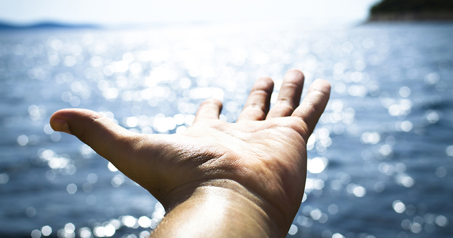 Hand outstretched over water